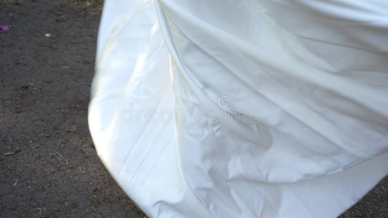 Beautiful blonde in a white wedding dress. Runaway Bride. Fear of weddings, breakup concept. Runs through the park from