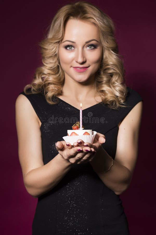 Beautiful Blonde Woman In Luxury Black Dress And Curly Hairstyle Blowing Candle On Birthday Cake