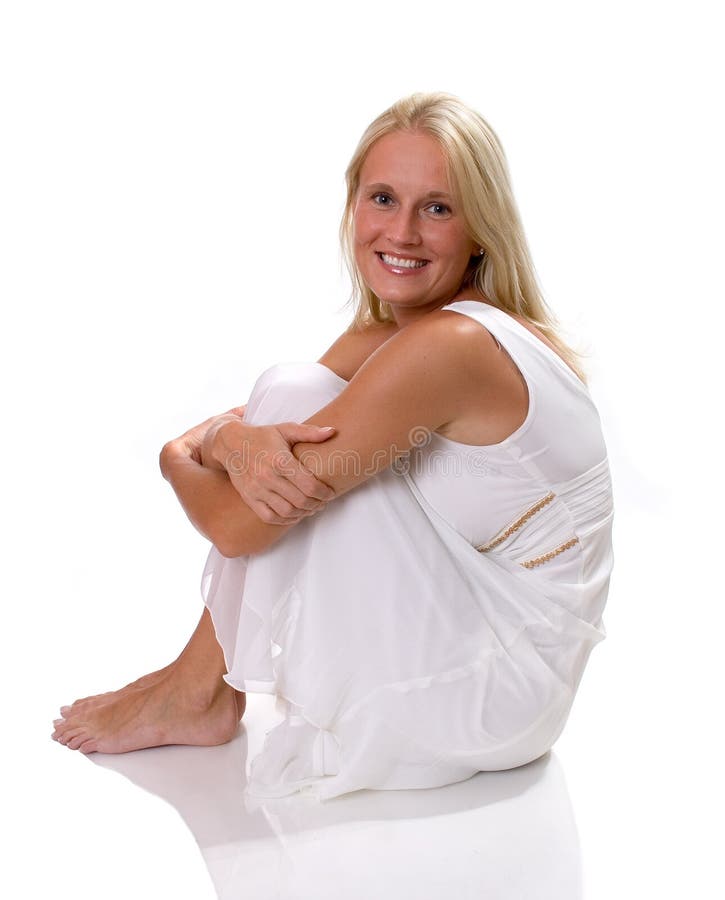 Beautiful blonde woman sitting in white dress