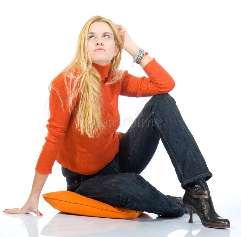 Beautiful blondy sitting on pillow and posing