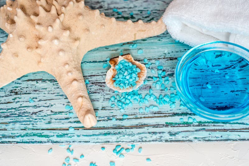Beautiful blue spa composition. blue sea salt, liquid soap, starfish, shells and a white bath towel stock photo Beautiful blue spa composition. blue sea salt, liquid soap, starfish, shells and a white bath towel stock photo