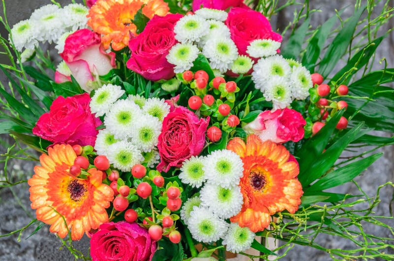 Beautiful bouquet with fresh pink roses, gerberas, daisies, hypericum with dew drops in flower shop outdoors. Can be used as a stock image Beautiful bouquet with fresh pink roses, gerberas, daisies, hypericum with dew drops in flower shop outdoors. Can be used as a stock image
