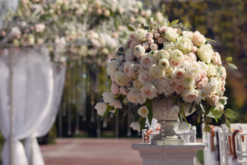Beautiful bouquet of roses in a vase on a background of a wedding arch. Beautiful set up for the wedding ceremony. royalty free stock image Beautiful bouquet of roses in a vase on a background of a wedding arch. Beautiful set up for the wedding ceremony. royalty free stock image