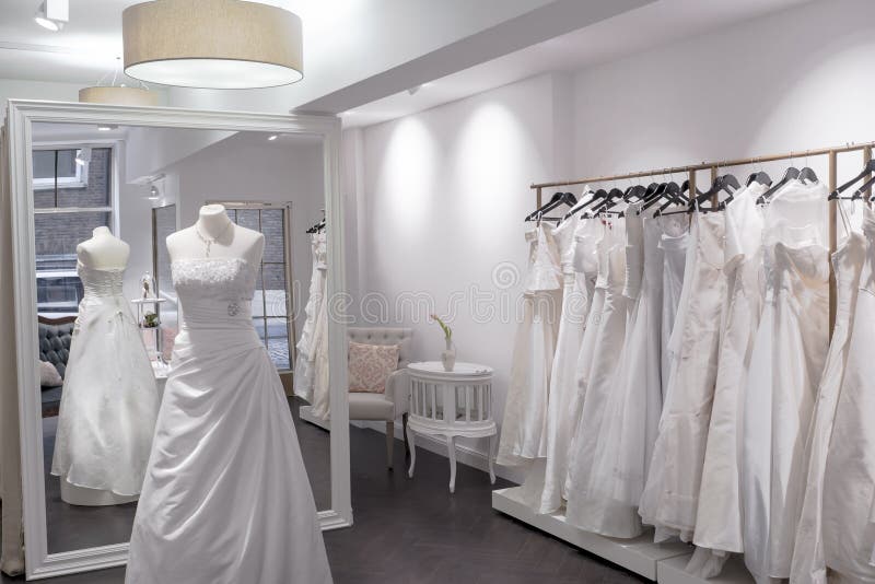 Wedding dress shop with mannequin, full length mirror, and selection of wedding gowns. Wedding dress shop with mannequin, full length mirror, and selection of wedding gowns