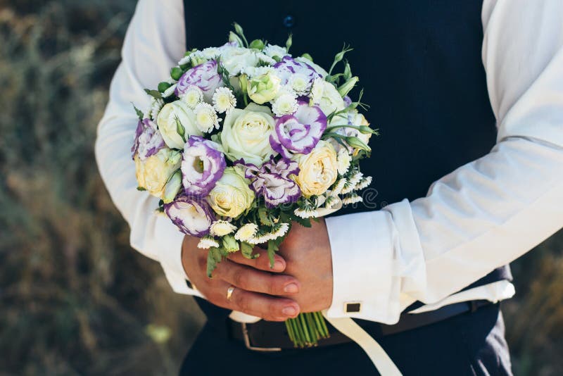 Beautiful Bridal Bouquet In Hands Of The Groom. Wedding Bouquet Of White  Roses, Hypericum, Lisianthus, Chrysanthemum, Eustoma Stock Photo - Image Of  Chrysanthemum, Bouquet: 100073754