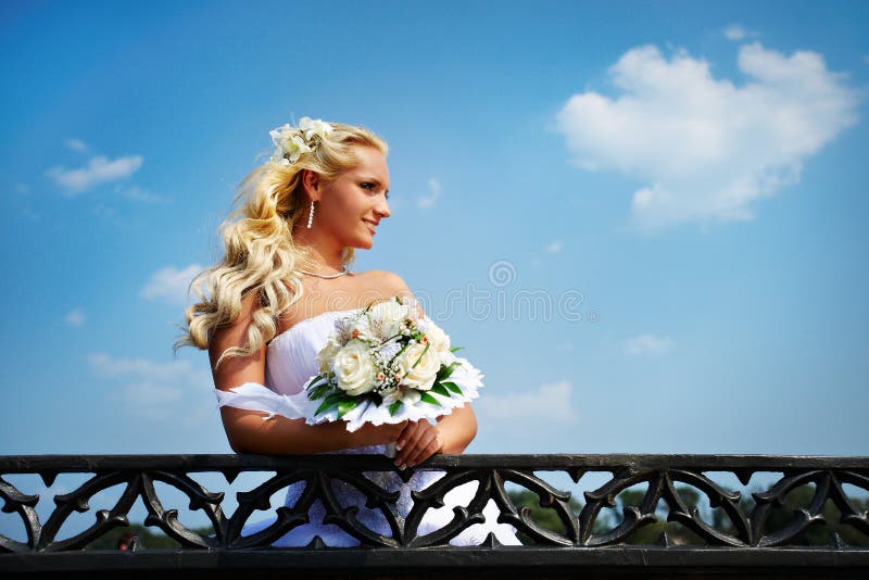 Beautiful bride with bouquet of flower near lake