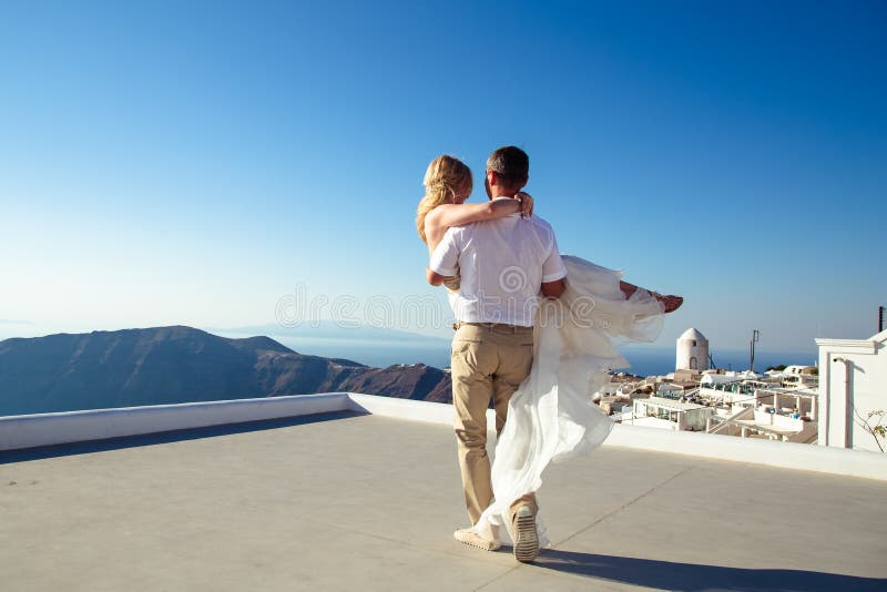 Beautiful bride and groom in their summer wedding day on greek island Santorini