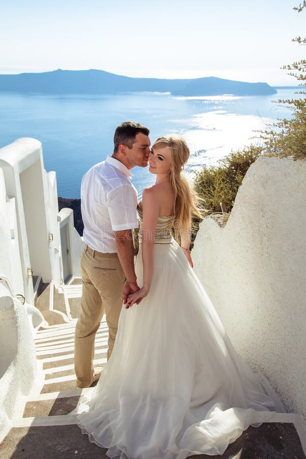 Beautiful bride and groom in their summer wedding day on greek island Santorini