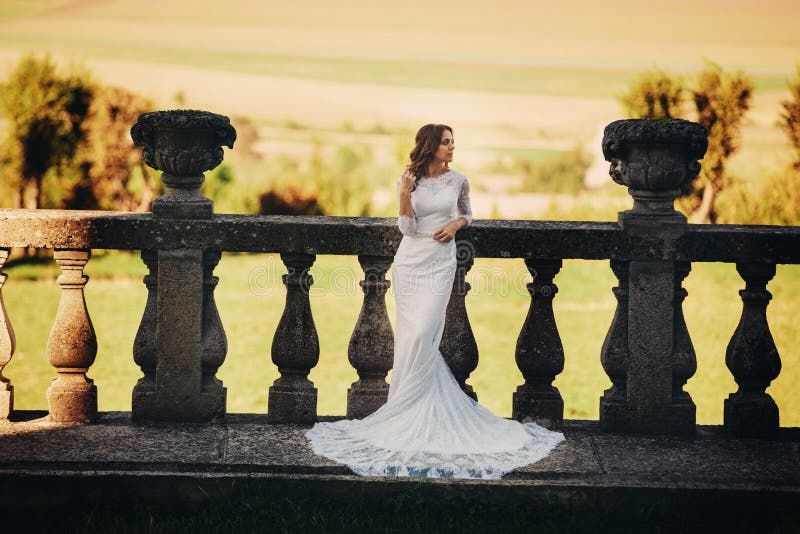 Beautiful bride in a luxurious dress standing on a large balcony royalty free stock images
