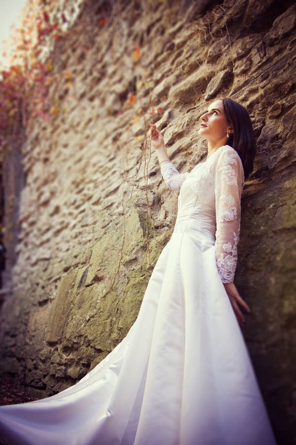 Beautiful bride near old wall