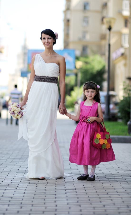 Beautiful bride posing together with flowergirl stock photo