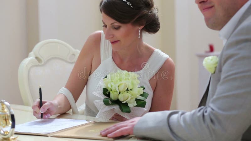 Beautiful bride signature in the documents at stock video