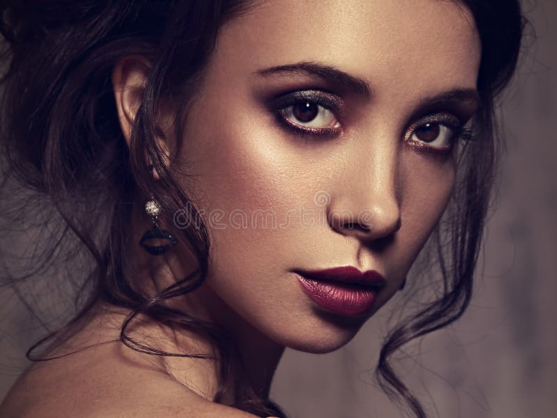 Beautiful bright amzing face makeup woman posing with burgundy lipstick and vamp look. Closeup