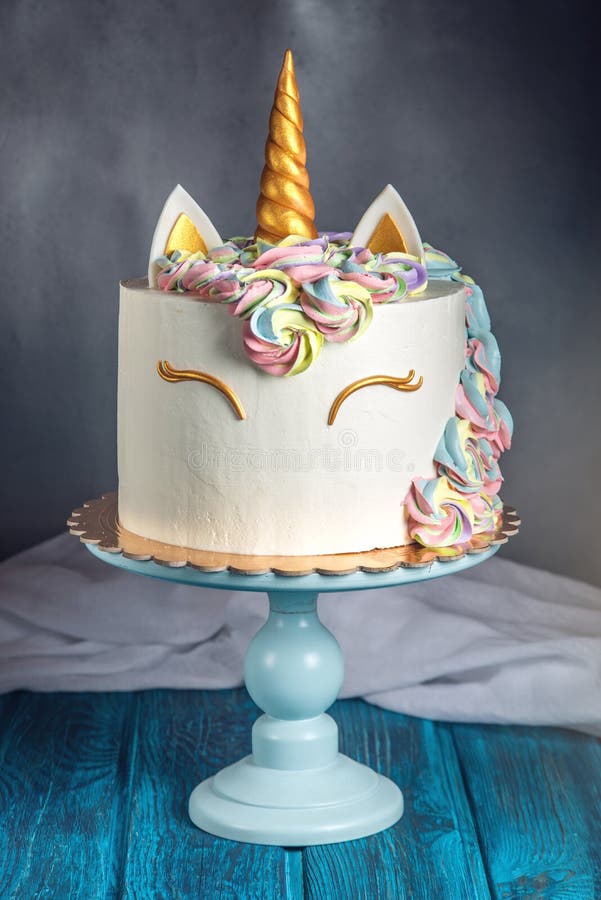 A beautiful bright cake decorated in the form of fantasy unicorn in the blue bookcase. The concept of a festive dessert for kids birthday. A beautiful bright cake decorated in the form of fantasy unicorn in the blue bookcase. The concept of a festive dessert for kids birthday