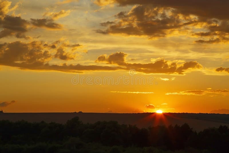 Beautiful bright majestic dramatic evening sky at sunset orange color with rays. The sun shines over the horizon against the royalty free stock photos Beautiful bright majestic dramatic evening sky at sunset orange color with rays. The sun shines over the horizon against the royalty free stock photos