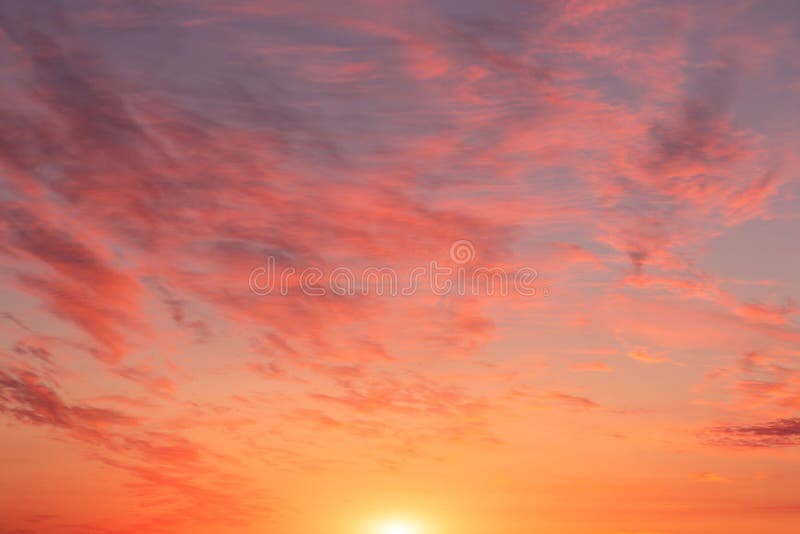 Sunrise, sunset pink yellow orange sky with sun and sunlight, clouds background texture