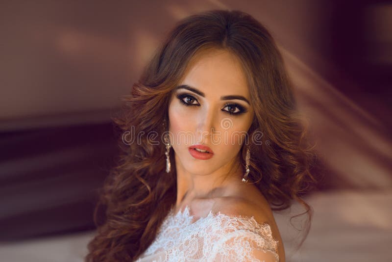 Beautiful brunette bride with ceremony make-up and curly hair