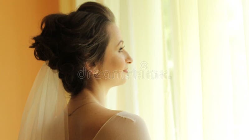 Beautiful brunette bride standing near the window