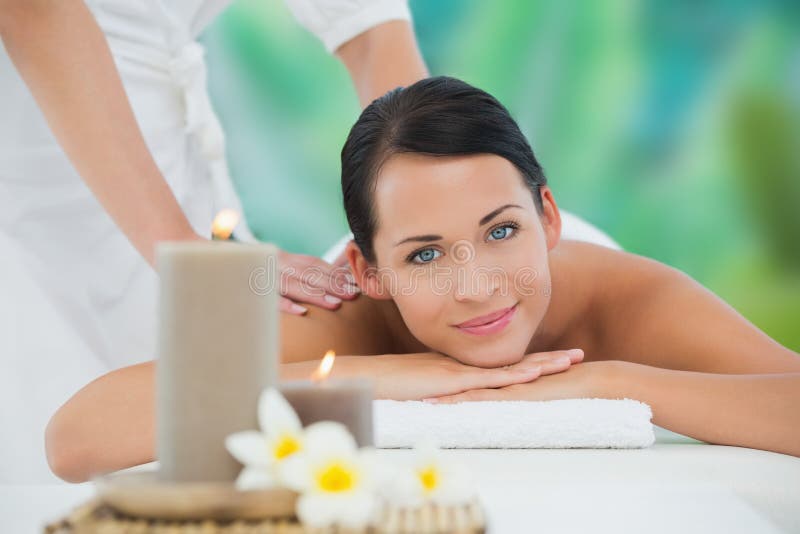 Beautiful Enjoying a Back Massage Smiling at Camera Stock