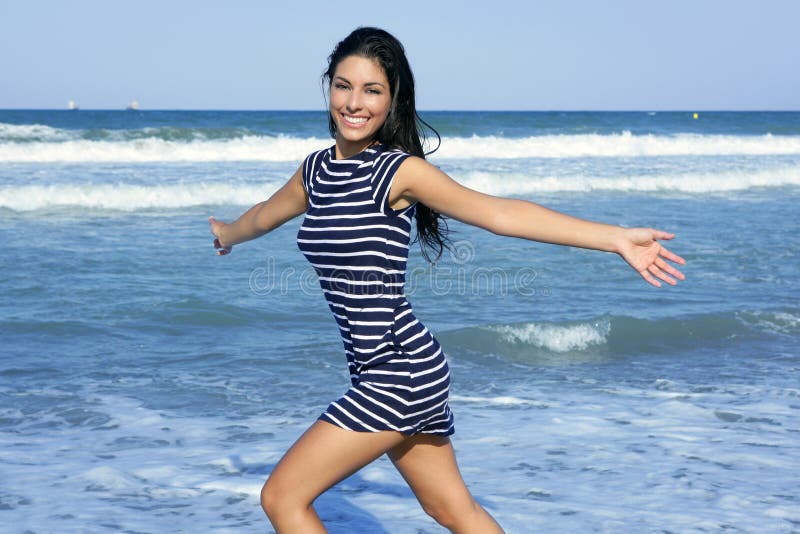 Beautiful brunette girl jumping on the beach