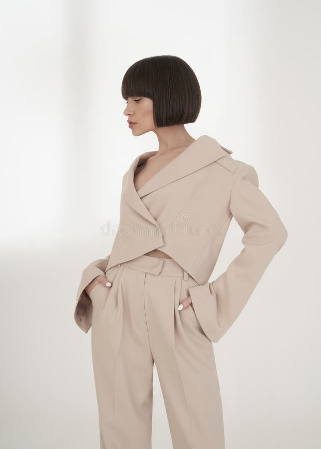 Beautiful brunette with graphic bob haircut wear beige fashion pantsuit