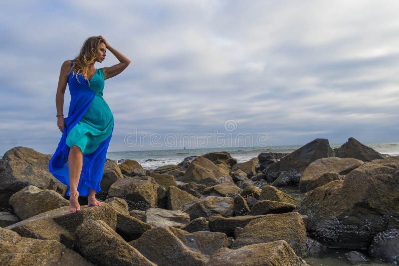 A Young Beautiful Woman In Fashionable Beach Clothes Poses And Looks At The  Camera On The Beach Among Bungalows Traveling Alone On Vacation On The  Island Of Outdoor High-Res Stock Photo -