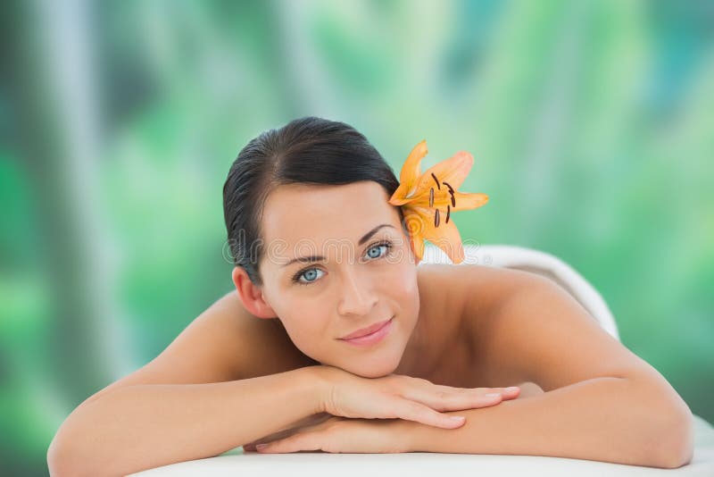 Beautiful Brunette Relaxing On Massage Table Smiling At Camera Stock