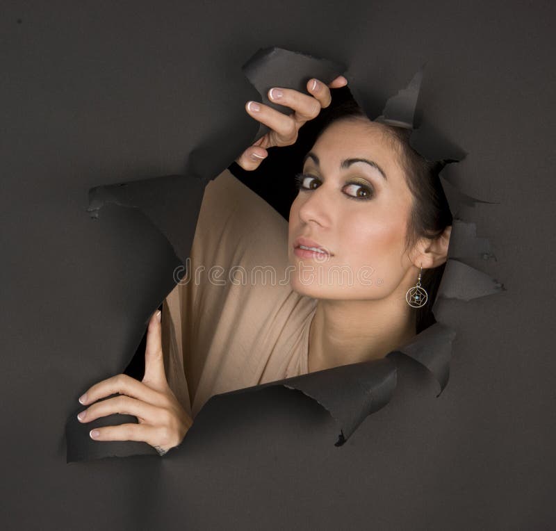 Beautiful Brunette Woman Looks Sideways Through Torn Hole Stock Image