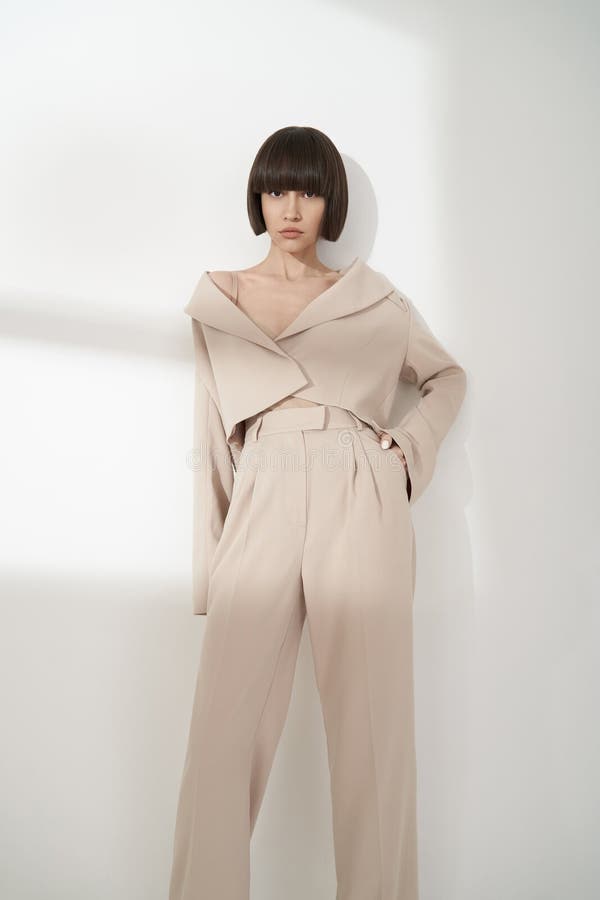 Beautiful brunette with graphic bob haircut wear beige fashion pantsuit