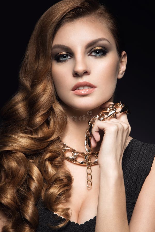 Beautiful Brunette Woman with Perfect Skin, Bright Makeup and Gold