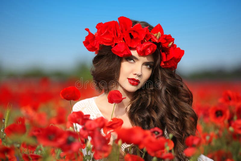Beautiful brunette woman in poppies field with flowers, attractive teen girl. Beauty outdoor model with red lips portrait.