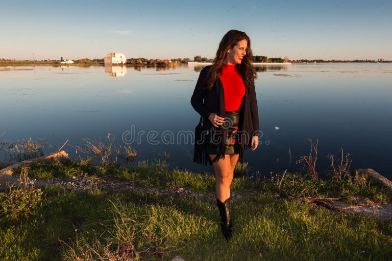 Beautiful brunette woman portrait standing outside in a sunny day, with a lake in background stock photos Beautiful brunette woman portrait standing outside in a sunny day, with a lake in background stock photos