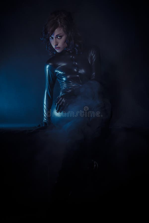 Beautiful brunette woman wearing latex dress on dark background art