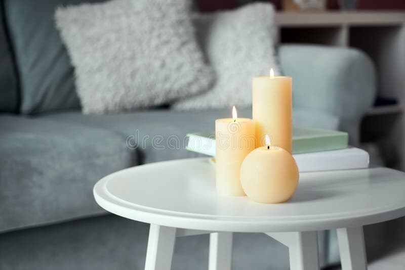 Beautiful Burning Candles with Books on White Table Indoors Stock Photo