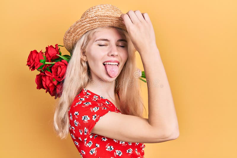 Beautiful caucasian woman with blond hair holding bouquet of red roses sticking tongue out happy with funny expression stock image Beautiful caucasian woman with blond hair holding bouquet of red roses sticking tongue out happy with funny expression stock image