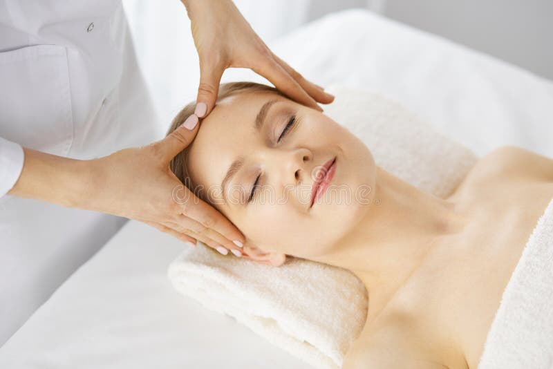Beautiful Caucasian Woman Enjoying Facial Massage With Closed Eyes In Spa Salon Relaxing