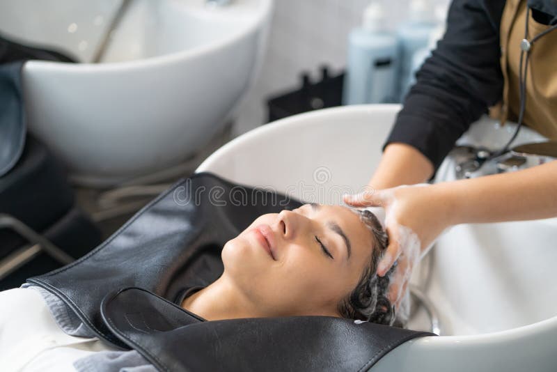 Beautiful Caucasian Women Feel Relax And Comfortable While Getting Hair Wash With Shampoo And