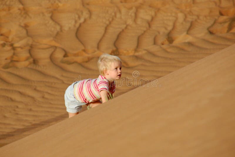 Child climbing sand dune