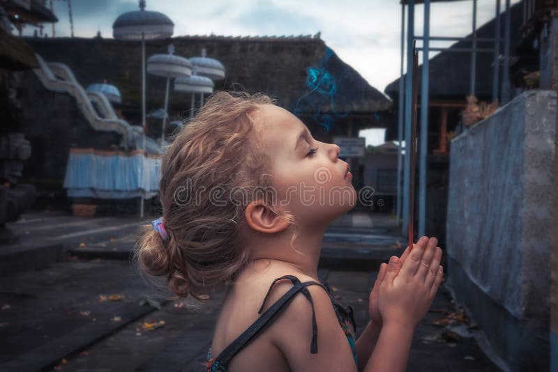Child girl praying in temple concept for hope and faith royalty free stock image