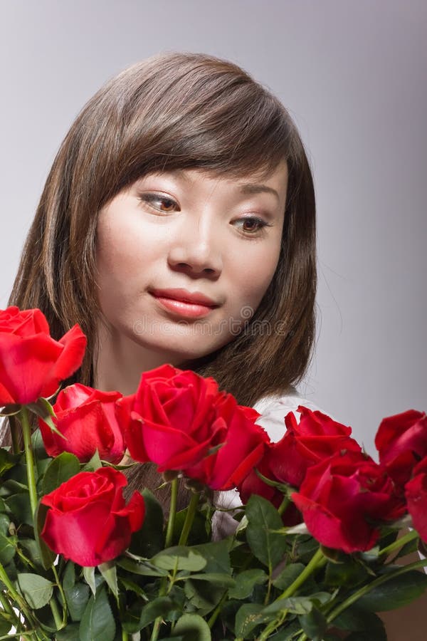 Beautiful chinese woman and red roses royalty free stock photography