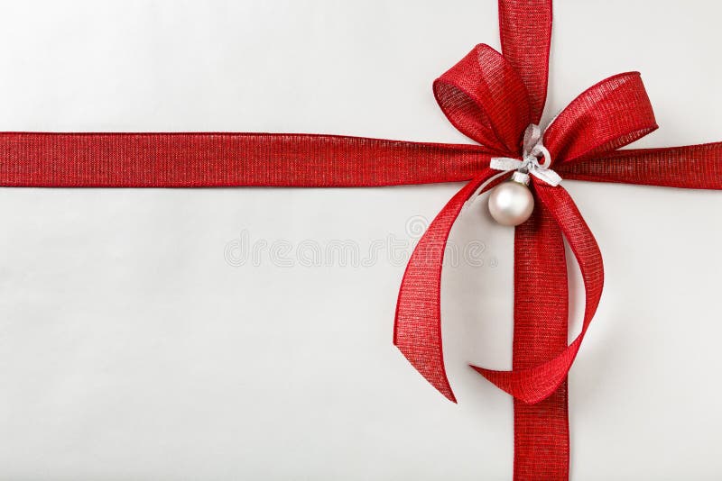 Beautiful, festive, fancy Christmas gift present with silver wrapping paper and bright red wired fabric ribbon bow. Horizontal background border with empty blank space. Beautiful, festive, fancy Christmas gift present with silver wrapping paper and bright red wired fabric ribbon bow. Horizontal background border with empty blank space.