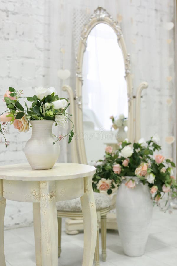 Beautiful classical room with vintage table, vase and flowers, heart decorations and pictures