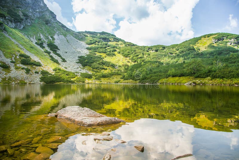 Krásné, čisté jezero v horském údolí za klidného slunečného dne. Horská krajina s vodou v létě.