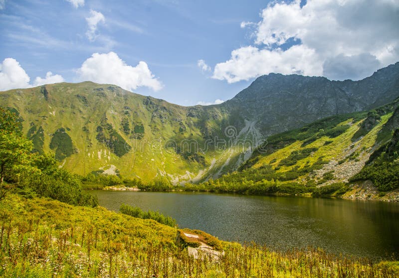 Krásné, čisté jezero v horském údolí za klidného slunečného dne. Horská krajina s vodou v létě.