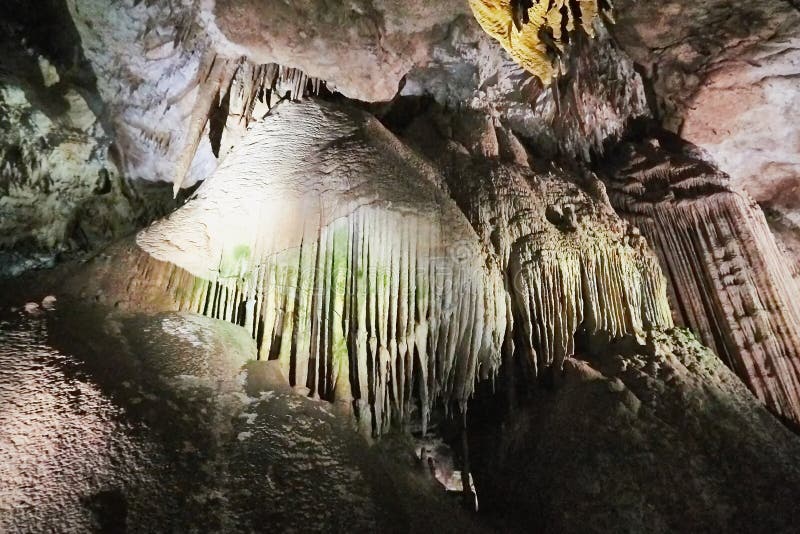 Beautiful colorful and illuminated cave with stalactites and stalagmites stock image