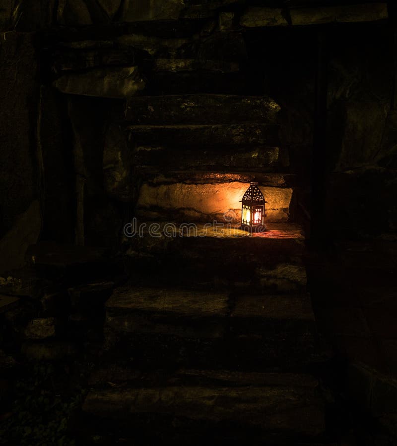 Beautiful colorful illuminated lamp in the garden in misty night. Retro style lantern at night outdoor