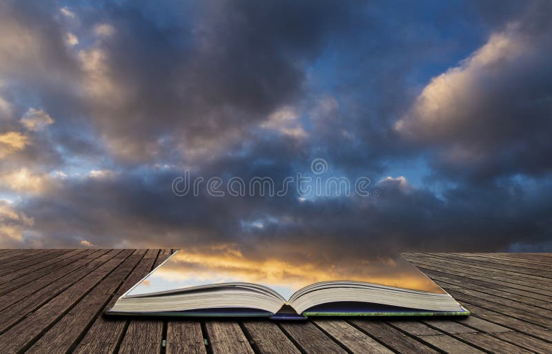 Beautiful colorful vibrant golden hour sunset skyscape with cloud formation and setting sun in pages of open book, story telling