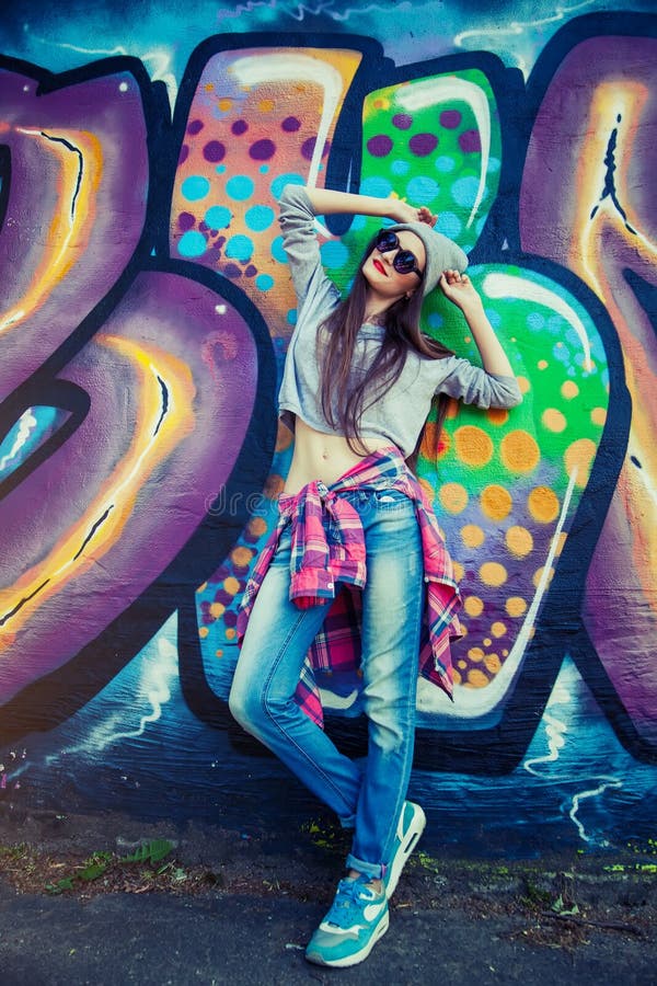 Beautiful Cool Girl in Hat and Sunglasses Over Graffiti Wall Editorial ...