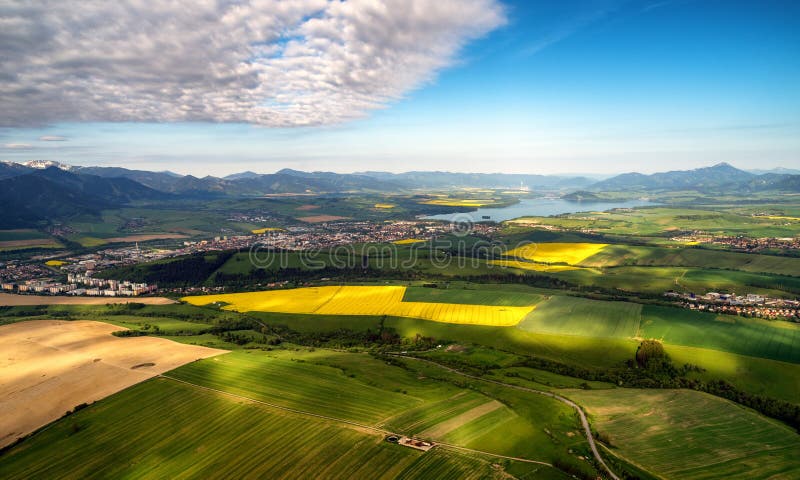 Beautiful country landscape with green, yellow fields and lake at background. Liptov, Slovakia