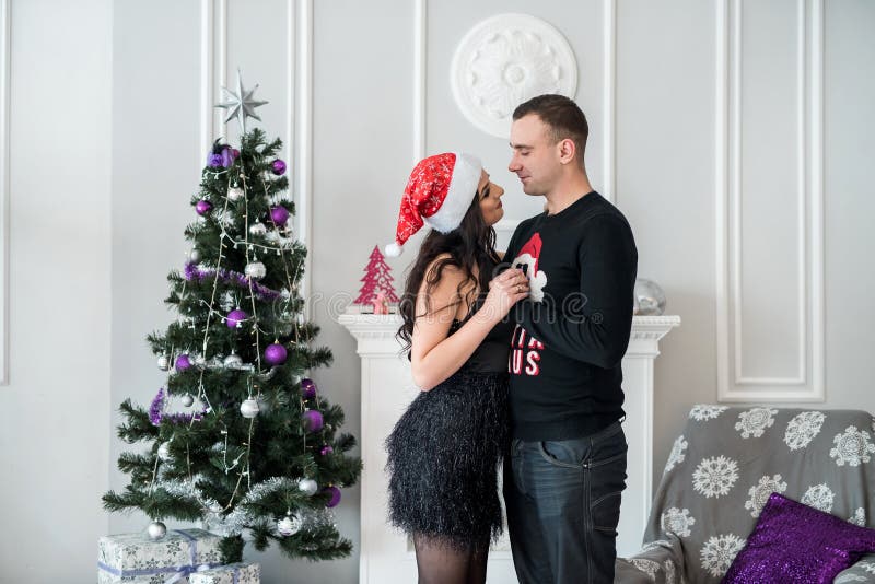 Beautiful Couple with Christmas Tree Posing at Studio Stock Image